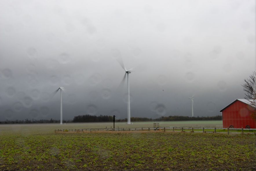 Wind turbines in Ontario turn quietly in the rain.